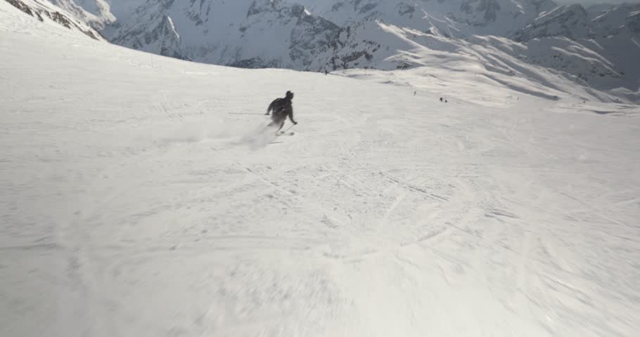 Skiing in the Alps, skier going fast descend, dynamic follow POV shot