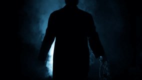 Mysterious Man in a Long Coat Walking with Rope and Axe in Dramatic Lighting | Cinematic Scene HD - Powered by Shutterstock - Get 15% off with code: PIKWIZARD15