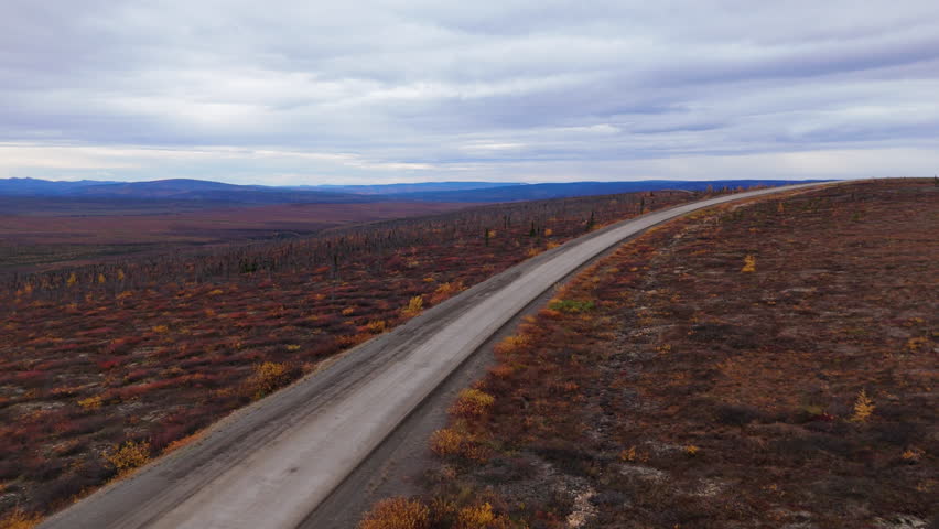 Paved Road Of Dempster Highway Through Autumn Nature Of Eagle Plains In Yukon, Canada. Aerial Drone Shot