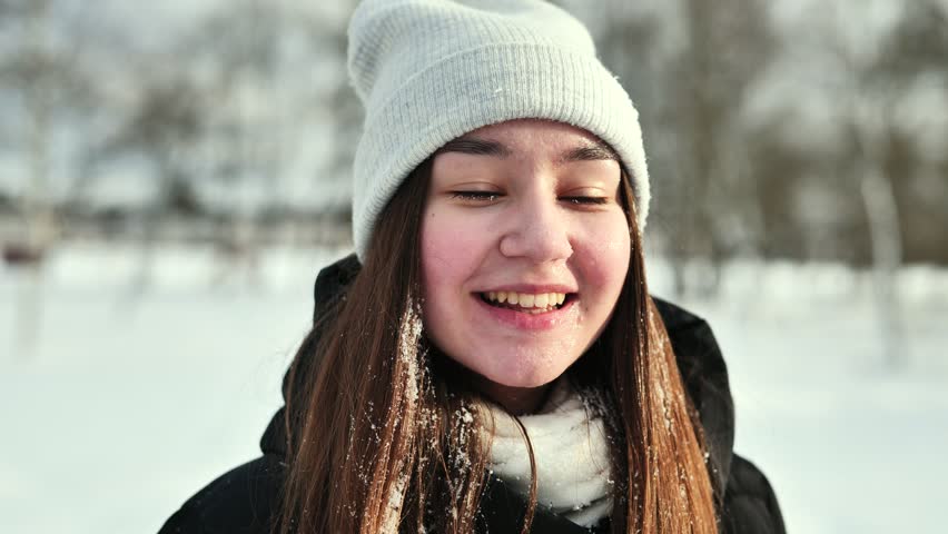 Teenage girls capturing moments with a smartphone and embracing in the outdoors on a winter day