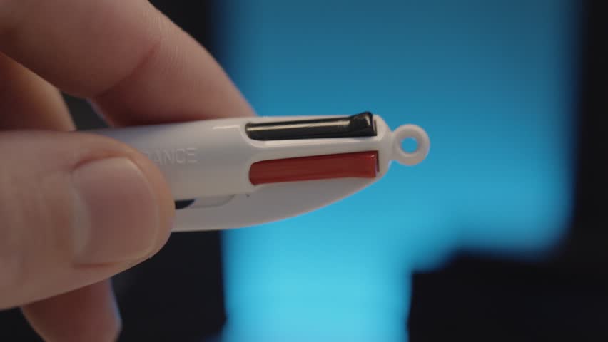 close-up shot of a person changing colours on a ballpoint pen