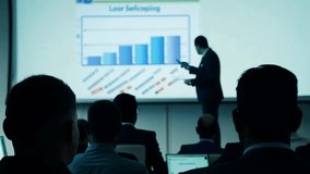 Motivated Businessman Leads Business Meeting. Employee Man Talks to audience about Company Growth. Conference for office workers. Creative Digital Entrepreneurs Summit. Graph on Tv Presentation screen - Powered by Shutterstock - Get 15% off with code: PIKWIZARD15