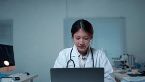 Doctor raising her arms in victory while working on a laptop in a hospital office, expressing joy and success - Powered by Shutterstock - Get 15% off with code: PIKWIZARD15