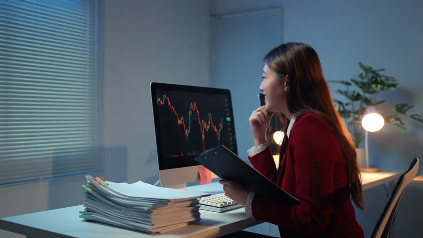 Businesswoman analyzes stock market data on a computer, displaying various emotions and reactions to the fluctuating trends - Powered by Shutterstock - Get 15% off with code: PIKWIZARD15