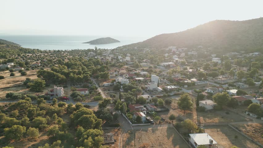 Aerial View of a Picturesque Greek Village by the Sea and Mountains