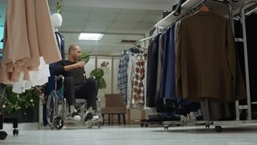 Middle eastern man with an impairment shopping for the new fashion collection, buying new apparel from the mall showroom. Young adult in wheelchair with a lot of clothing options. Camera B. - Powered by Shutterstock - Get 15% off with code: PIKWIZARD15
