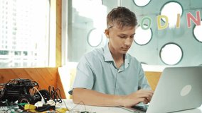 Smart teenager working on laptop and looking at camera at STEM technology class. Caucasian student using computer to analyze data while smiling with confident on table with car model. Edification - Powered by Shutterstock - Get 15% off with code: PIKWIZARD15