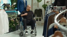 Middle eastern man with an impairment shopping for the new fashion collection, buying new apparel from the mall showroom. Young adult in wheelchair with a lot of clothing options. Camera A. - Powered by Shutterstock - Get 15% off with code: PIKWIZARD15