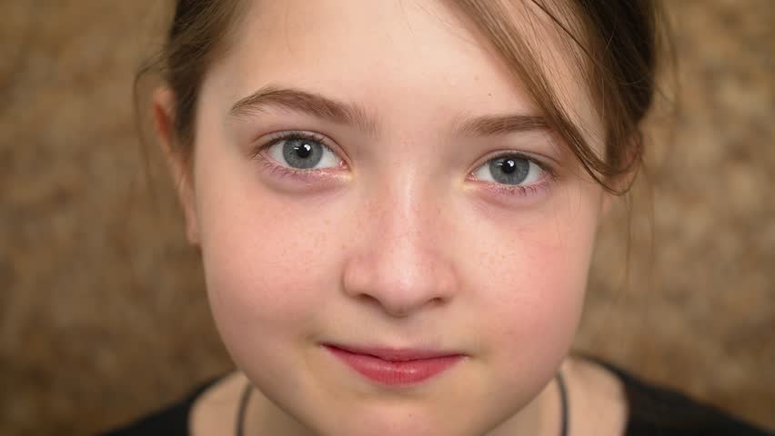 Portrait cute young girl with large gray eyes at home. Close up adorable child with big gray eyes indoors. Sweet little girl with striking gray eyes inside her home