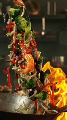 Super Slow Motion of Flying Asian Meal with Vegetable and Prawns into Wok Pan. Filmed on High Speed Cinema Camera, 1000 fps