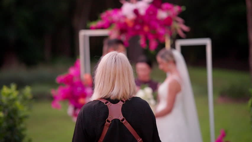 Focus Behind Blonde Wedding Photographer At Bright Outdoor Wedding Ceremony, 4K Slow Motion