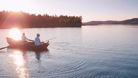 Aerial shot of an older couple rowing and fishing on a romantic sunset lake - Powered by Shutterstock - Get 15% off with code: PIKWIZARD15
