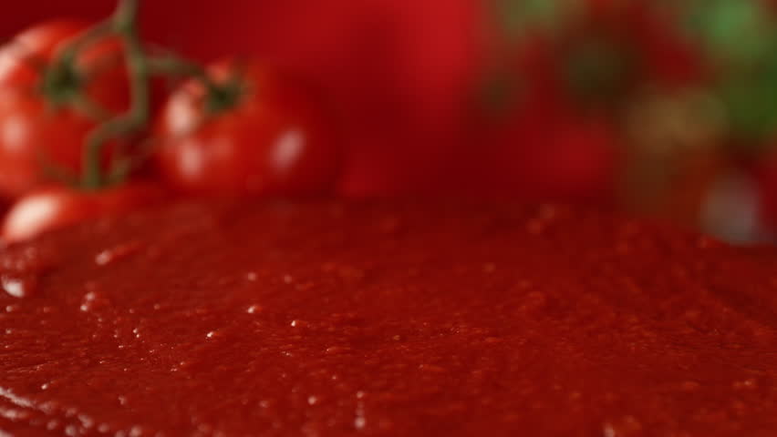 Super Slow Motion Shot of Fresh Tomato Falling and Splashing into Sauce at 1000fps.