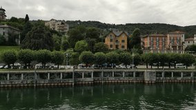 Vertical drone video flight of northern Italy Stresa Lago Maggiore, of cars moving at main lakeside road surrounded by traditional red roof buildings - Powered by Shutterstock - Get 15% off with code: PIKWIZARD15