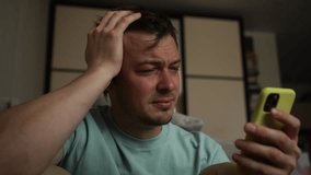 Young man holds a smartphone while crying, visibly upset by distressing content on the screen. Emotions of sadness and despair overwhelm him in this moment of vulnerability - Powered by Shutterstock - Get 15% off with code: PIKWIZARD15