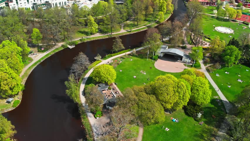 Aerial view of a dark river and a green park. In Orebro, Sweden