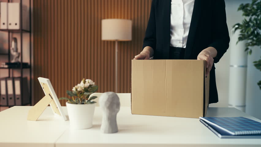 Close-up of office worker packing her items after getting fired, exiting her job