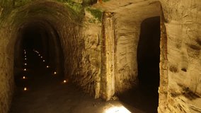 Long, Straight Cave with Side Niches, with Burning Candles Lined Along the Edges. A Cave or Cavern is a Natural Void Under the Earths Surface or Artificial, Carved into Rocks by People. - Powered by Shutterstock - Get 15% off with code: PIKWIZARD15