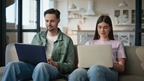 Working couple discussing laptop screen talking together at couch closeup. Busy lovers texting computers at home. Relaxed man looking wife asking question at flat. Young spouses lifestyle concept - Powered by Shutterstock - Get 15% off with code: PIKWIZARD15