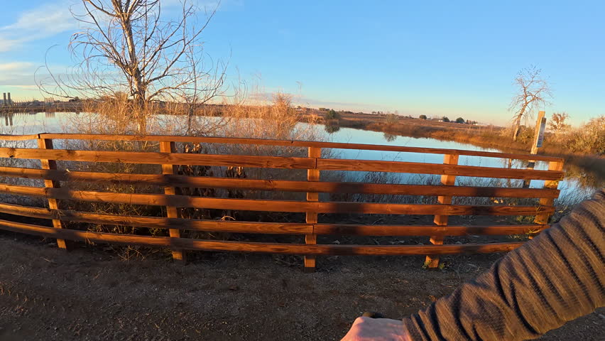 First person POV from riding a mountain bike on a long trestle across a lake, fall scenery in northern Colorado, Great Western Bike Trail
