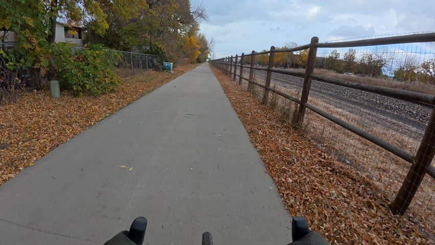 First person POV from riding a touring bike on a paved commuting trail along railroad in Fort Collins, Colorado, in fall scenery