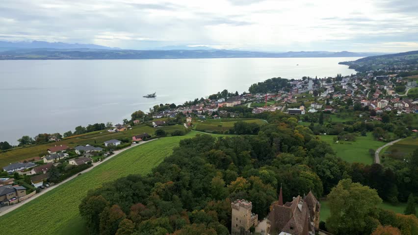 Pull out drone shot of Lake Neuchatel and Gorgier Castle in Switzerland