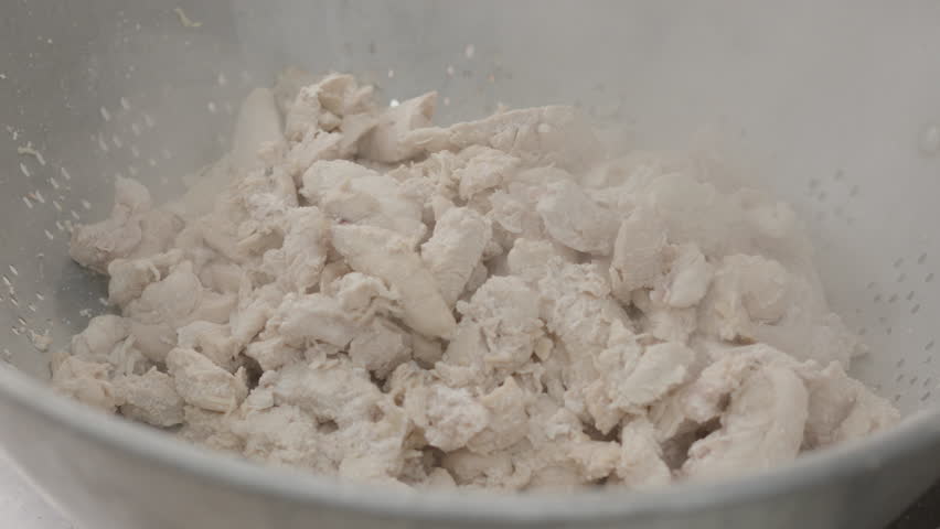 COOKED CHICKEN BEING DUMPED INTO A COIN FULL OF CHICKEN