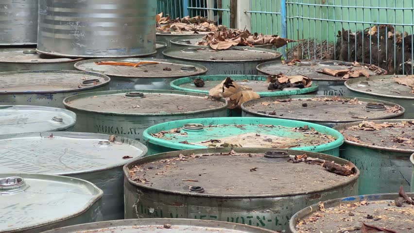 Close-up shot of abandoned barrels of chemical waste on a site.