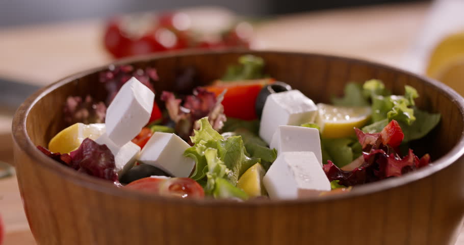 Colorful Fresh Salad with Feta Cheese falling into a Bowl of Vegetables Showcasing Mediterranean Diet, Balanced Eating, and Vibrant Healthy Nutrition