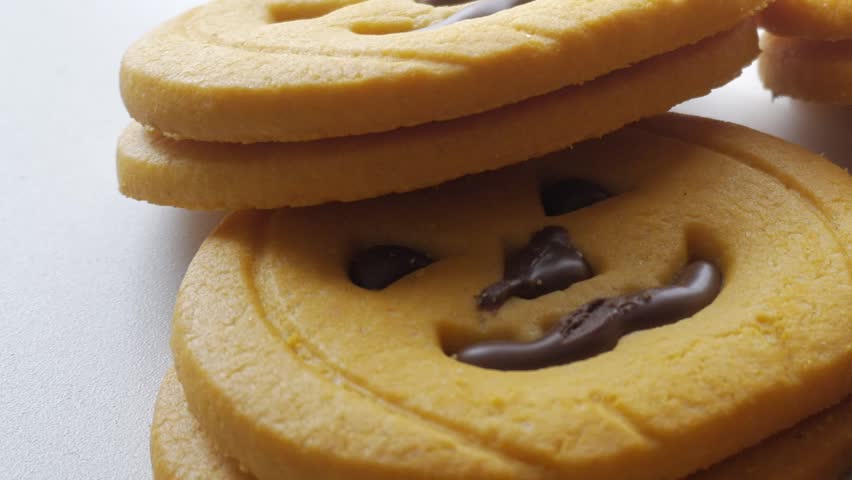 Slow motion truck shot of delicious pumkin cookies foor halloween with cinnamon, close up with white background