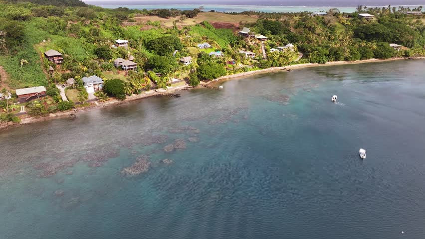 Pristine tropical shoreline of Vanua Levu island in Fiji. Houses and small hotel buildings. Drone