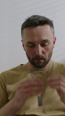 Vertical shot of soldier in military uniform having panic attack from PTSD