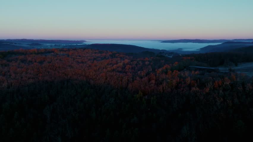 Aerial view of sunset over the hills with mist