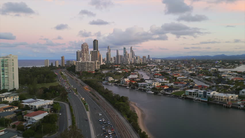 Aerial over the Gold Coast highway approaching downtown Surfers Paradise at sunset
