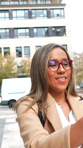 Latin woman visiting a city and taking photos with mobile phone enjoying the day in the city