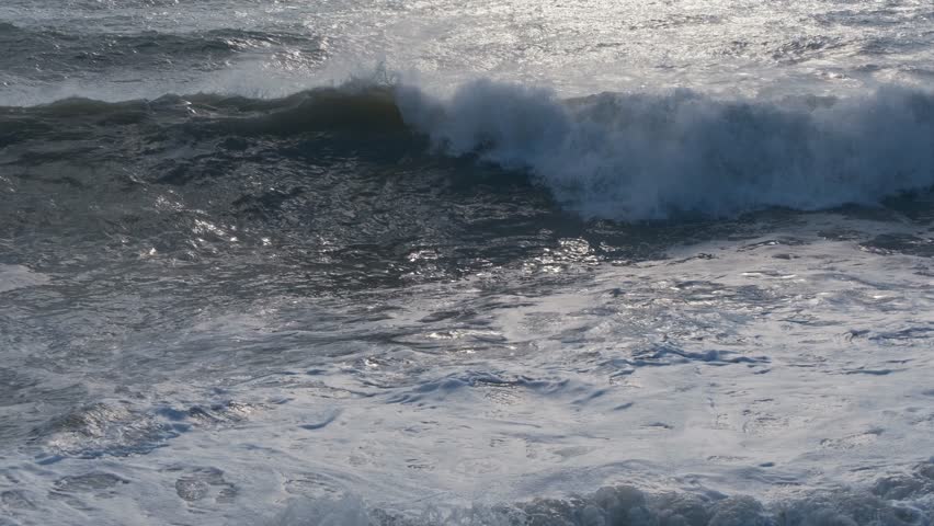 powerful waves rage in Mediterranean sea, Konyaalti, Antalya, Turkiye. Stormy waves splashing foam fizz sea, blue sky.