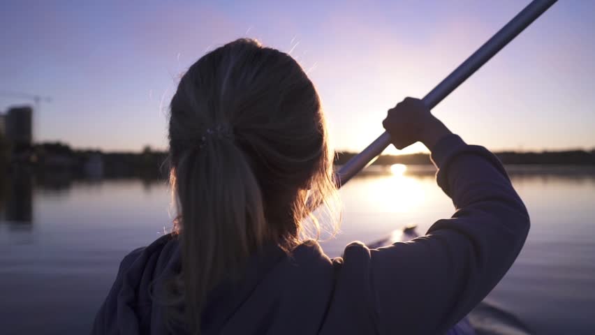 oar paddles on calm water against the background of sunset rays, outdoor activities on a kayak,