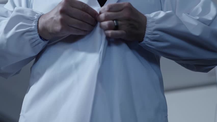 Description: Rising shot from a lower angle captures a sushi chef putting on his uniform, emphasizing professionalism and readiness in the kitchen. Ideal for culinary and preparation-focused content.
