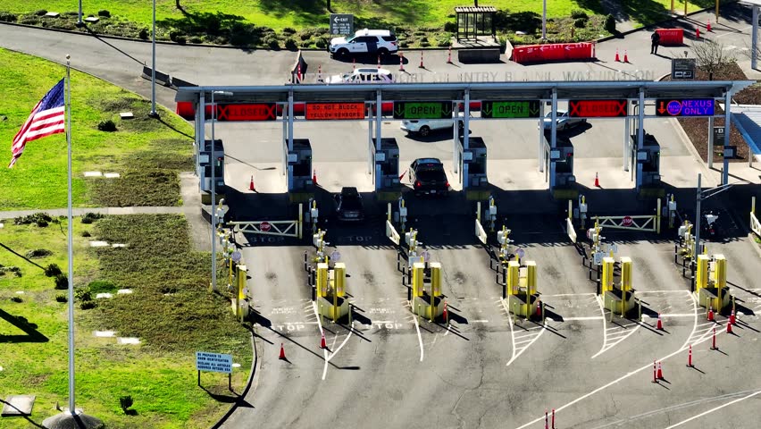 South Surrey, BC–Blaine, WA - Vehicles Near the Border Crossing, Characterized by Inspection Lanes and a Prominently Displayed American Flag - Aerial Drone Shot