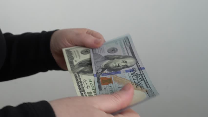 Close-up of women's hands with old and new dollars.
Two hands hold 2 banknotes with a face value of $ 100 of the old and new sample, examine them and compare them