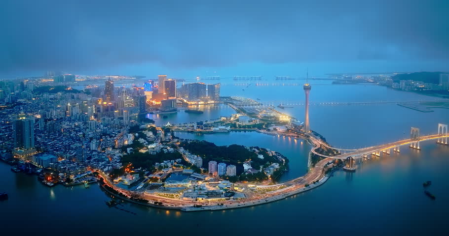 Panoramic view of Macau modern city buildings skyline and bridge over the ocean at night