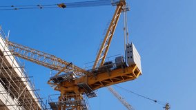 Tower crane or mobile crane erected beside under construction building.
Yellow color Tower crane used for lifting heavy items from ground to top level.
Building Cranes for under construction building - Powered by Shutterstock - Get 15% off with code: PIKWIZARD15