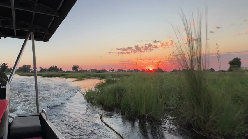 boat ride through Okovango delta botswana with sunset