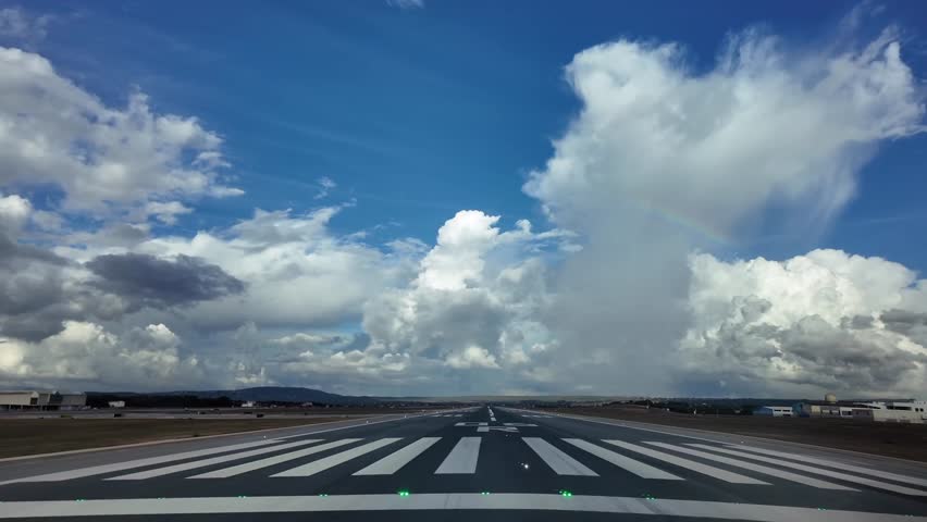 Real time takeoff from Palma de Mallorca’s airport in a stormy day with some cottony clouds in a blue sky and with a rainbow ahead. Immersive pilot’s perspective. 4K 60FPS