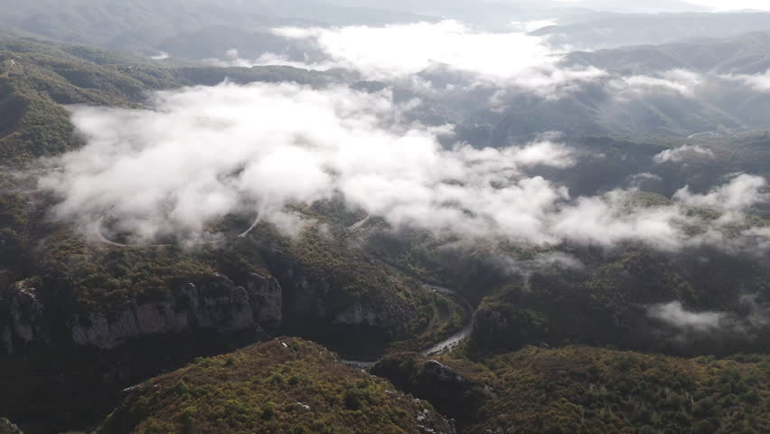 Thick clouds drifting over Vikos Gorge roadway, creating a moody and scenic landscape in Zagori