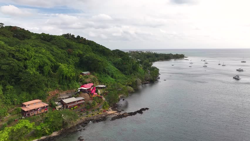 Tropical shoreline with building and boats in Vanua Levu Island, Fiji. Drone crane shot horizon
