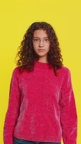 Oh my God, Wow. Excited amazed girl taking off eyeglasses in surprise looking at camera with big eyes blinking shocked by victory celebrating success achievement good news. Child on yellow background