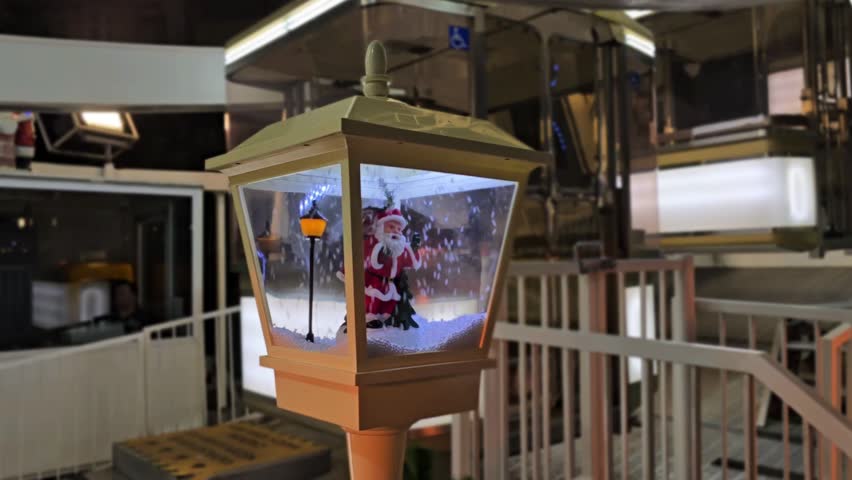 Illuminated Ferris wheel in the center of Budapest, Hungary in the night with a cute lantern with Santa and snow in the foreground.