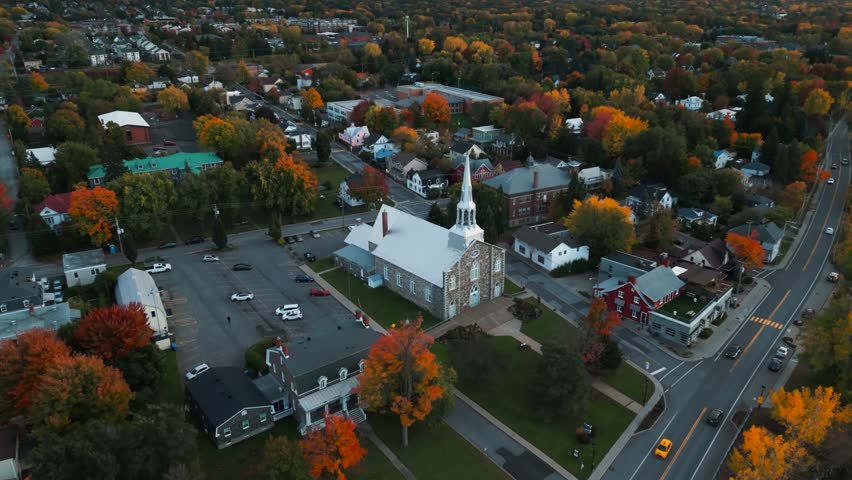 aerial shot revealing the town of Mont Saint Hilaire in Quebec province near Montreal during fall season with Saint Hilaire Church in the foreground and Mont Saint Hilaire in the background, Canada