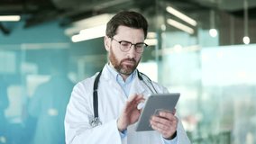 Male doctor in white coat using digital tablet standing in modern hospital clinic. Medical worker physician chats online with patient, Device is used for data analysis, works in an app, communication - Powered by Shutterstock - Get 15% off with code: PIKWIZARD15